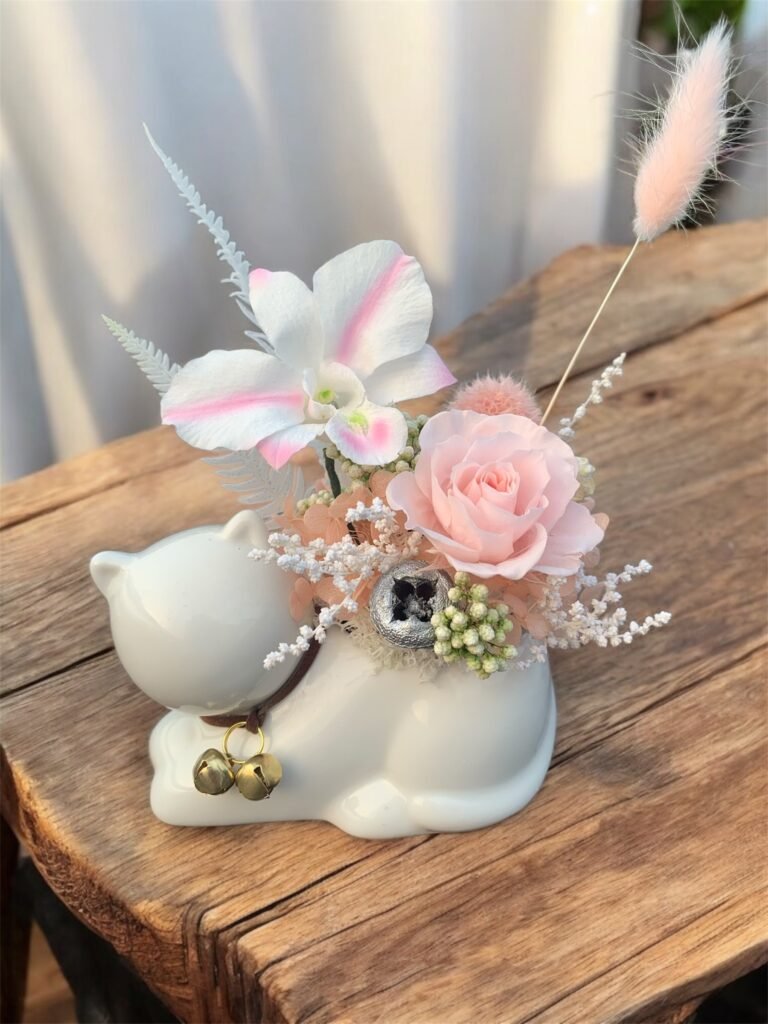 table decoration of preserved flowers (rose & orchid) in a lovely cat container